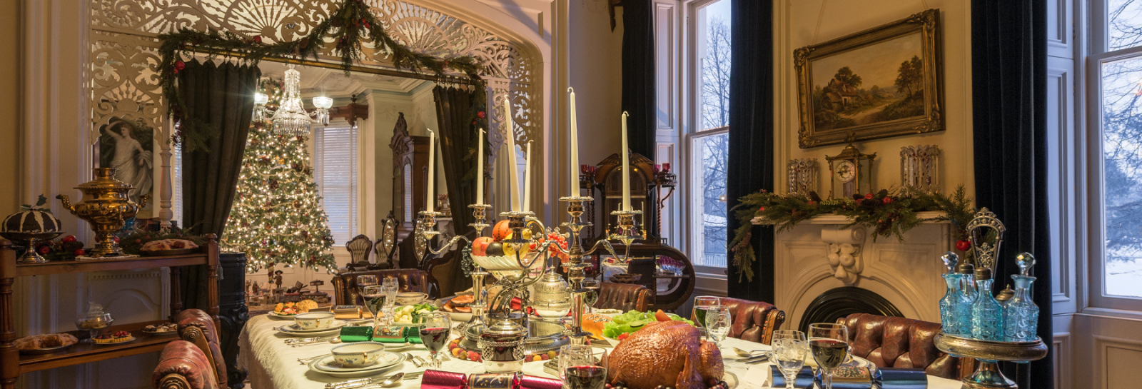Image of Victorian dining table set for Christmas with large christmas tree in the background