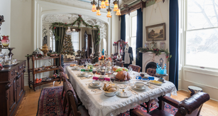 Image of Victorian dining table set for Christmas with large christmas tree in the background