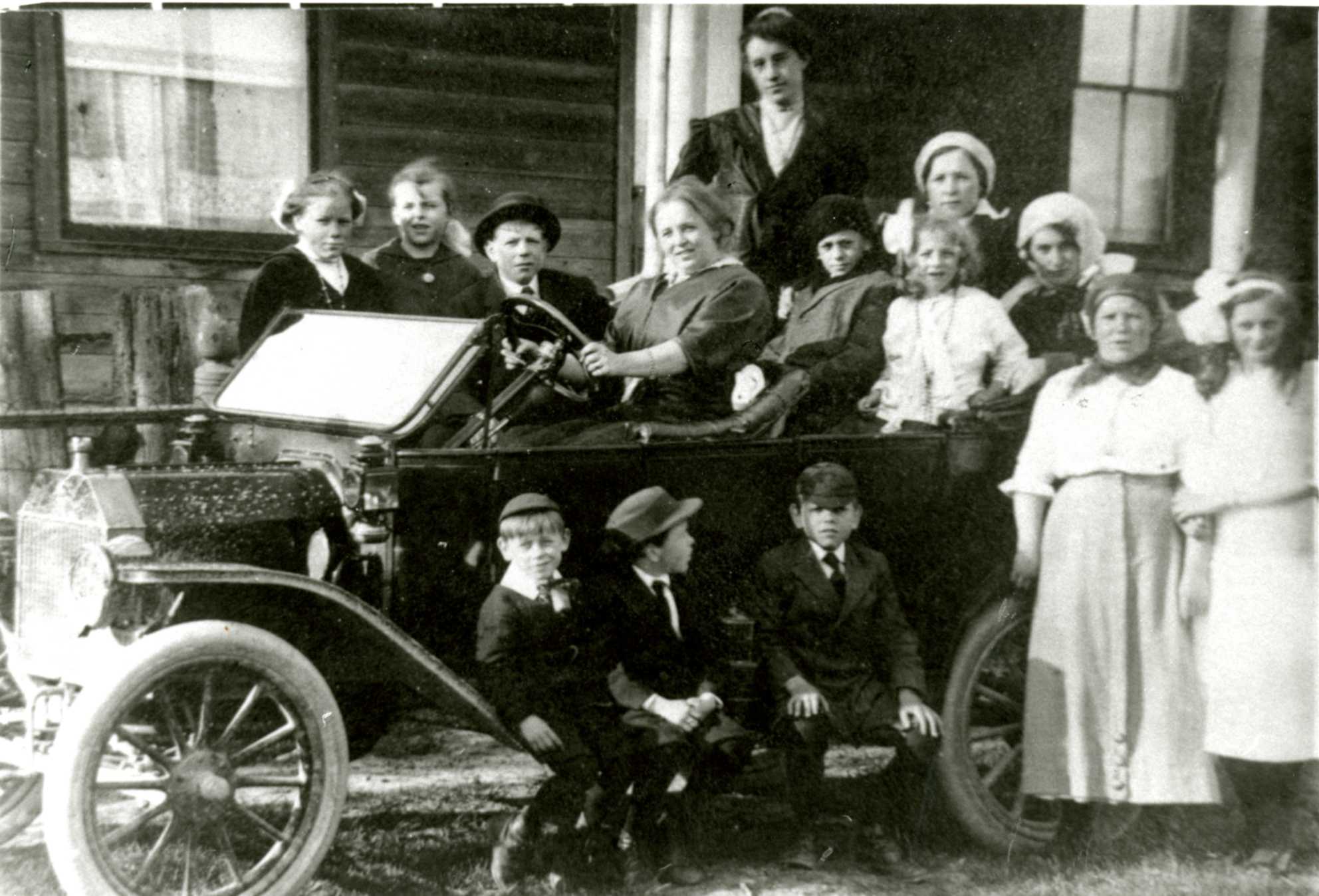 Old car with people gathered around